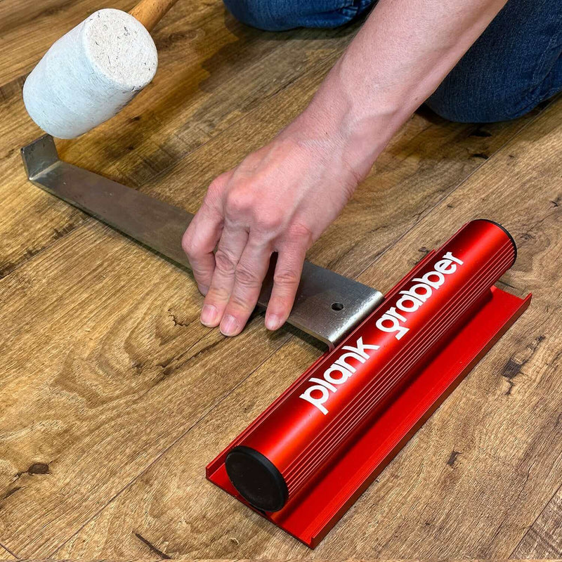 Load image into Gallery viewer, Floor Fix Pro Plank Grabber Plank Grabber is a tool for fixing gaps in floating floors. It features a &quot;Magic Grip Strip&quot; that sticks to the plank you want to move using nano-suction and without leaving any sticky residue. Plank Grabber can be used to fix
